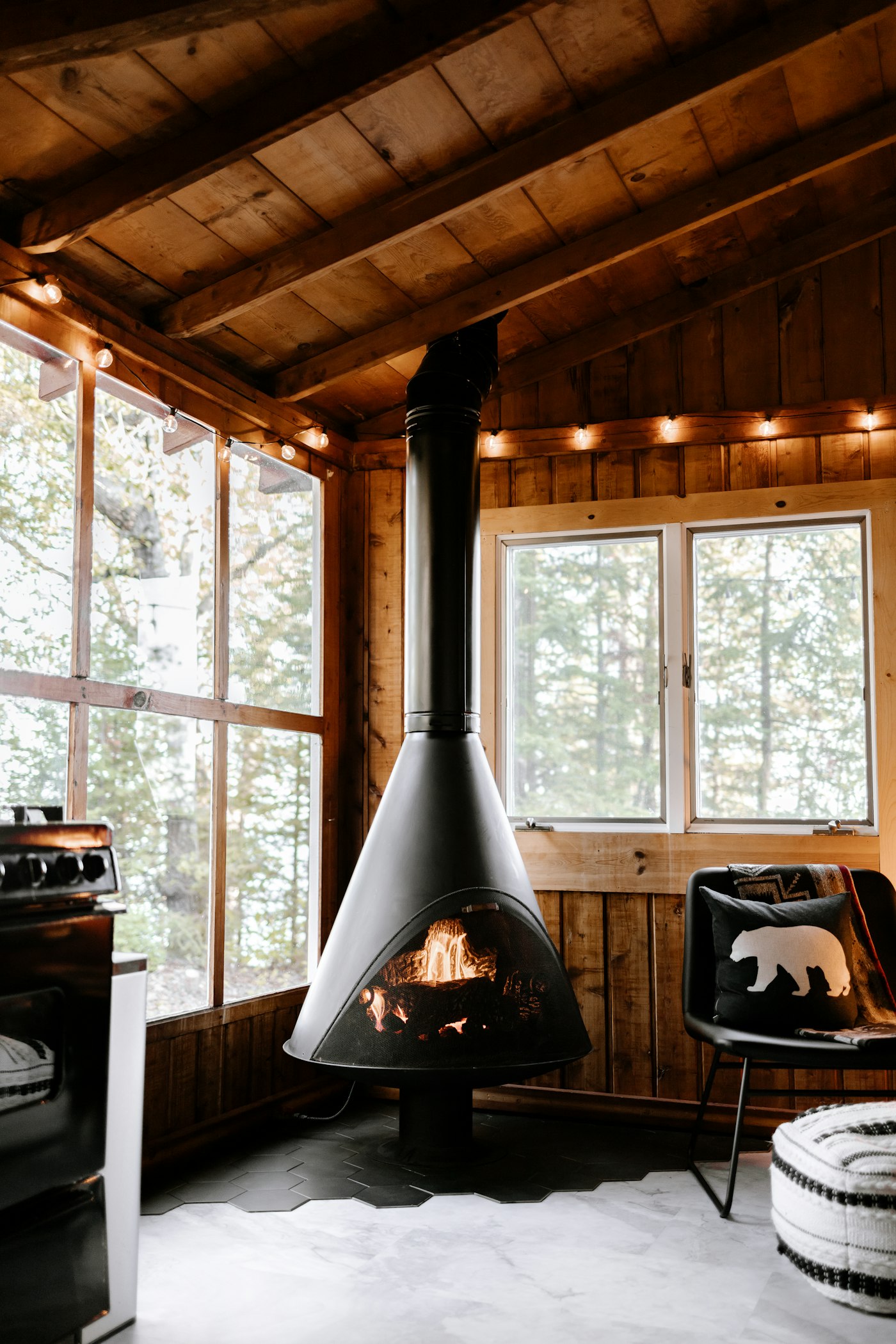 The wood stove burning in the corner of the cabin