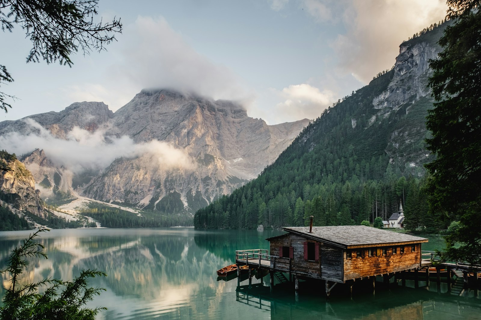 A cabin at the edge of a still mountain lake