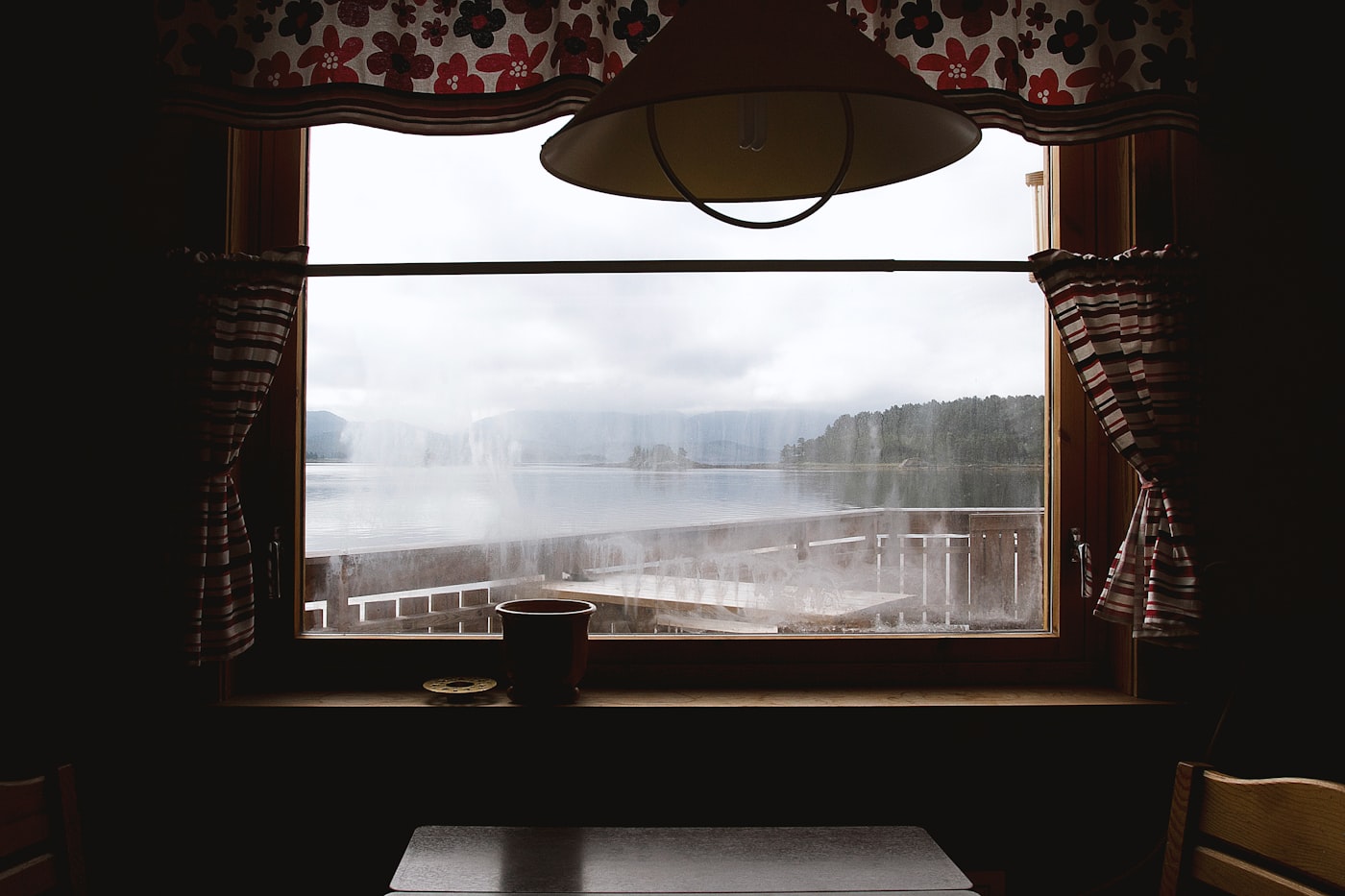 A table by a cabin window overlooking the water